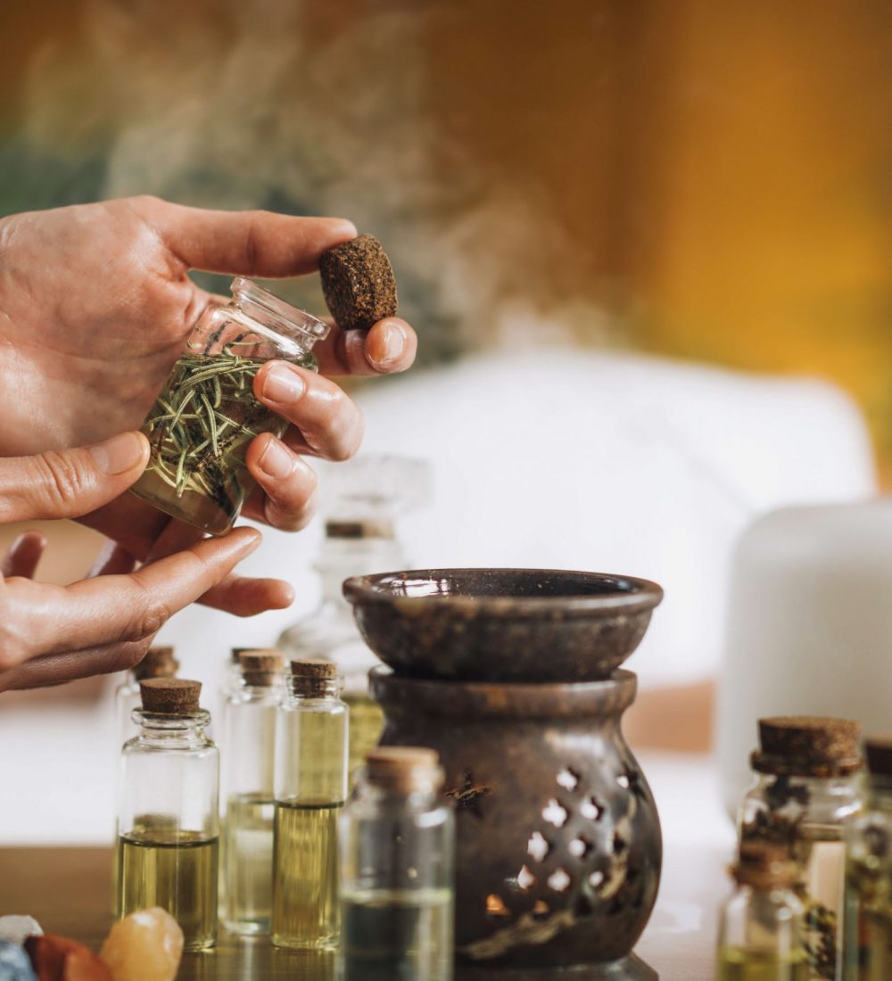 Ayurveda aromatherapy massage, female hand pouring aromatic oil in an essential oil diffuser