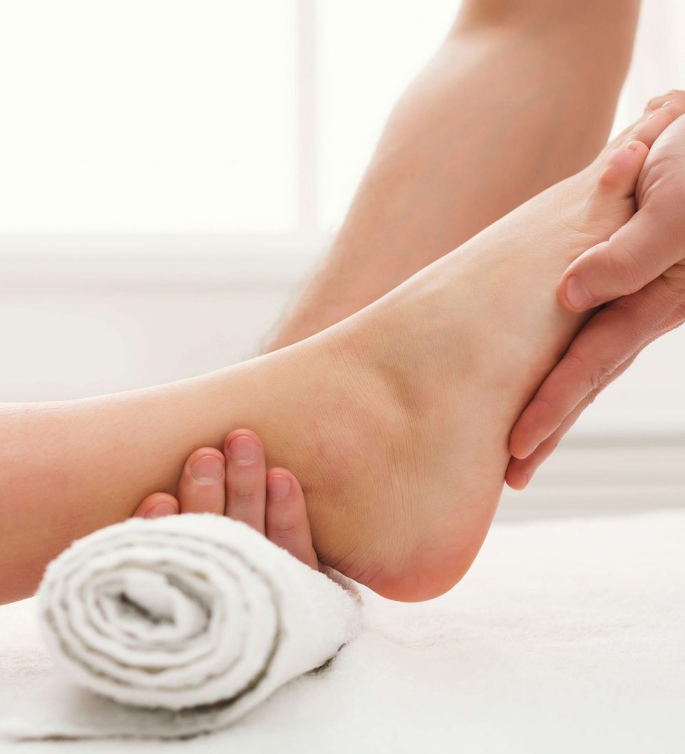 Leg massage. Physiotherapist pressing specific spots on female foot. Professional health and wellness acupressure manipulations, copy space, closeup